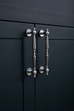 two metal handles on a black cabinet