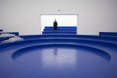 a man standing in the middle of a stage with blue steps leading up to it