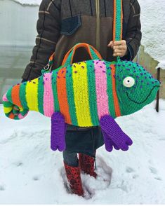 a person holding a knitted fish bag in the snow