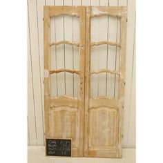 an old wooden double door with a chalkboard sign on the front and bottom panel