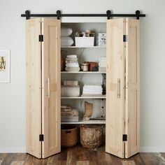 an open closet with two doors and baskets in it