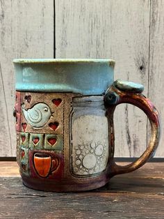 a ceramic coffee mug sitting on top of a wooden table