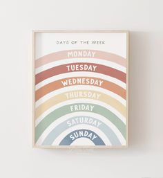 the days of the week poster in a wooden frame on a wall above a white wall