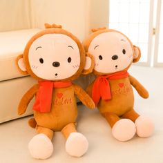 two stuffed monkeys sitting next to each other on a white surface with the word love written on them