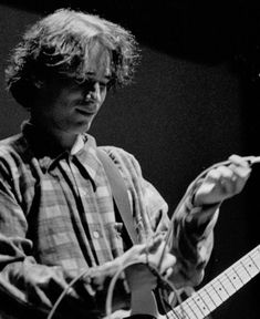 black and white photograph of a man playing an electric guitar