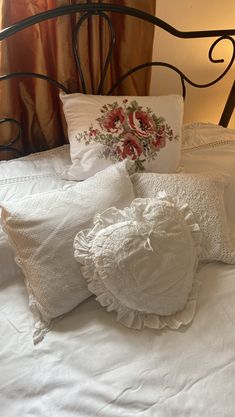 a bed with white linens and pillows on it