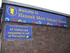 a sign on the side of a building that says hannah more infants school all visitors are requesting to call at reception