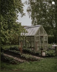 a small greenhouse in the middle of a garden