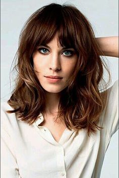 a woman with shoulder length hair and blue eyes is posing for a photo while wearing a white shirt