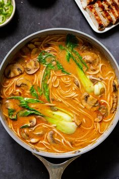 a pan filled with noodles and vegetables on top of a table