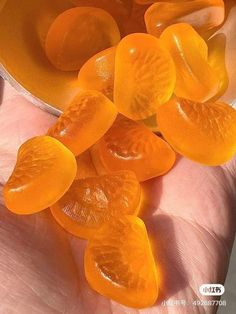 a person is holding some orange pieces in their hand