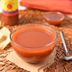 a bowl of sauce sitting on top of a wicker table