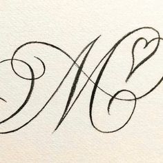 the letter m is written in cursive writing with black ink on white paper