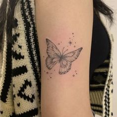 a woman's arm with a small butterfly tattoo on the left side of her arm