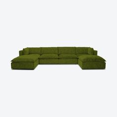 a large green couch sitting on top of a white floor