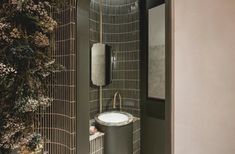 the bathroom is decorated in green and white with plants growing on the wall next to the sink