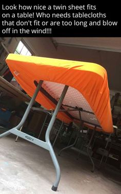 an orange table cover sitting on top of a metal frame