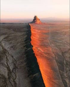 an aerial view of the desert with a mountain in the distance and water running through it