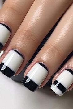 black and white nail polish with stripes on the tip of each manicured fingernail