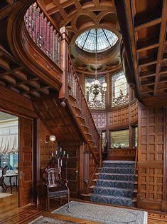 an ornate wooden staircase leads up to the second floor