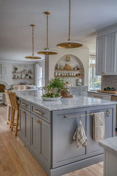 a large kitchen with an island in the middle and lots of counter space on one side