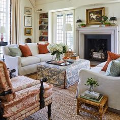 a living room filled with furniture and a fire place in front of a white fireplace