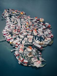 an aerial view of a city with lots of houses on it's sides and water in the foreground