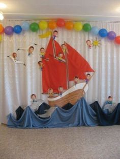 a birthday party with balloons and pictures on the wall, including a boat in the water