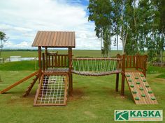 a wooden play set in the middle of a field