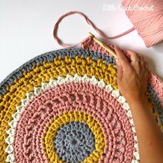 someone is crocheting a circular rug with yarn