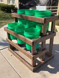 several green plastic cups are stacked on a wooden stand