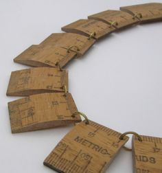 a necklace made out of wooden rulers on a white surface