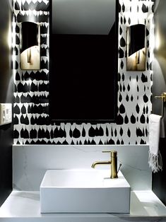 a white sink sitting under a bathroom mirror next to a wall mounted faucet