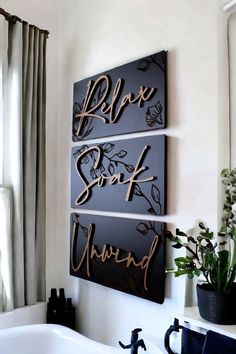 three metal signs hanging on the wall above a bathtub