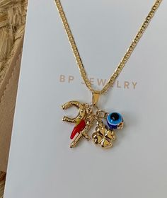 a gold necklace with two charms on it and a card that says bpp jewelry