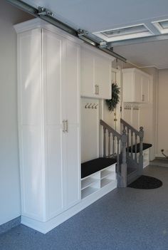 a room with white cupboards and stairs