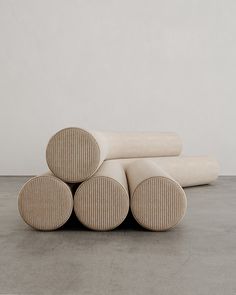 four round cushions stacked on top of each other in front of a white wall and floor