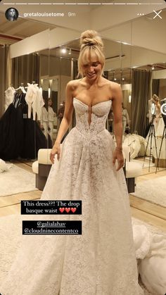 a woman in a wedding dress looking at her cell phone while standing in front of a mirror