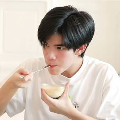 a young man eating cereal with a spoon