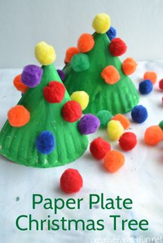 paper plate christmas tree craft with pom - poms on the top and bottom