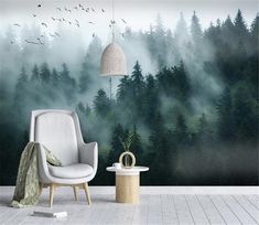 a chair and table in front of a forest wall mural