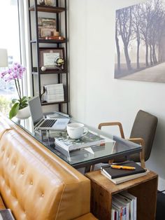 a living room with a couch, coffee table and bookshelf on the wall