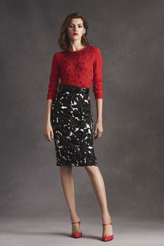 a woman in a red top and black skirt