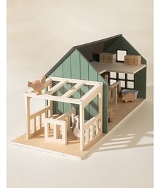 a wooden model of a house with an open floor plan and green roof, on a white background