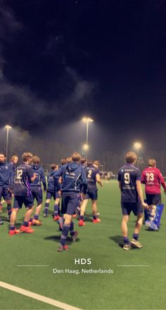 a group of men standing on top of a field next to each other in soccer uniforms