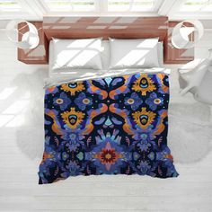 a bed with a blue and orange comforter on top of it