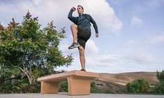 a man is doing tricks on a bench