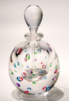 a clear glass bottle with multicolored confetti designs on it's top