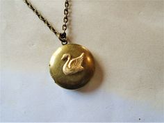 "A round brass locket with a swan on it is hanging from antiqued brass chain. The locket is a darkened brass and the swan is a made of raw brass giving it a golden color. You can select your length of chain at checkout. Locket measures approx. 1\" and opens to hold two small pictures. Necklace will come in a gift box and bow ready for gift giving. Enter back into store: rhondastreasures.etsy.com   RhondasTreasures" Ruby Locket, Mia 3, Dope Jewelry, Neck Jewellery, Small Pictures, Funky Jewelry, Girly Jewelry