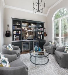 a living room filled with furniture and a book shelf next to a large open window